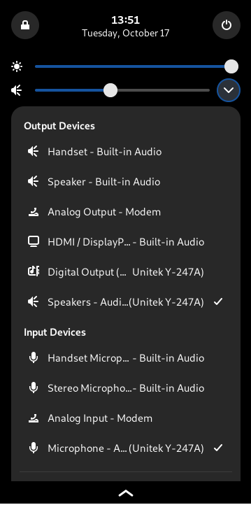 A drop-down screen from the top bar of phosh. It displays a number of quick settings buttons, and in addition, a drop down that shows all of my audio input and output devices, which can be clicked to select between them.